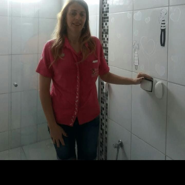 Maria Resolve ao lado de interruptor em banheiro